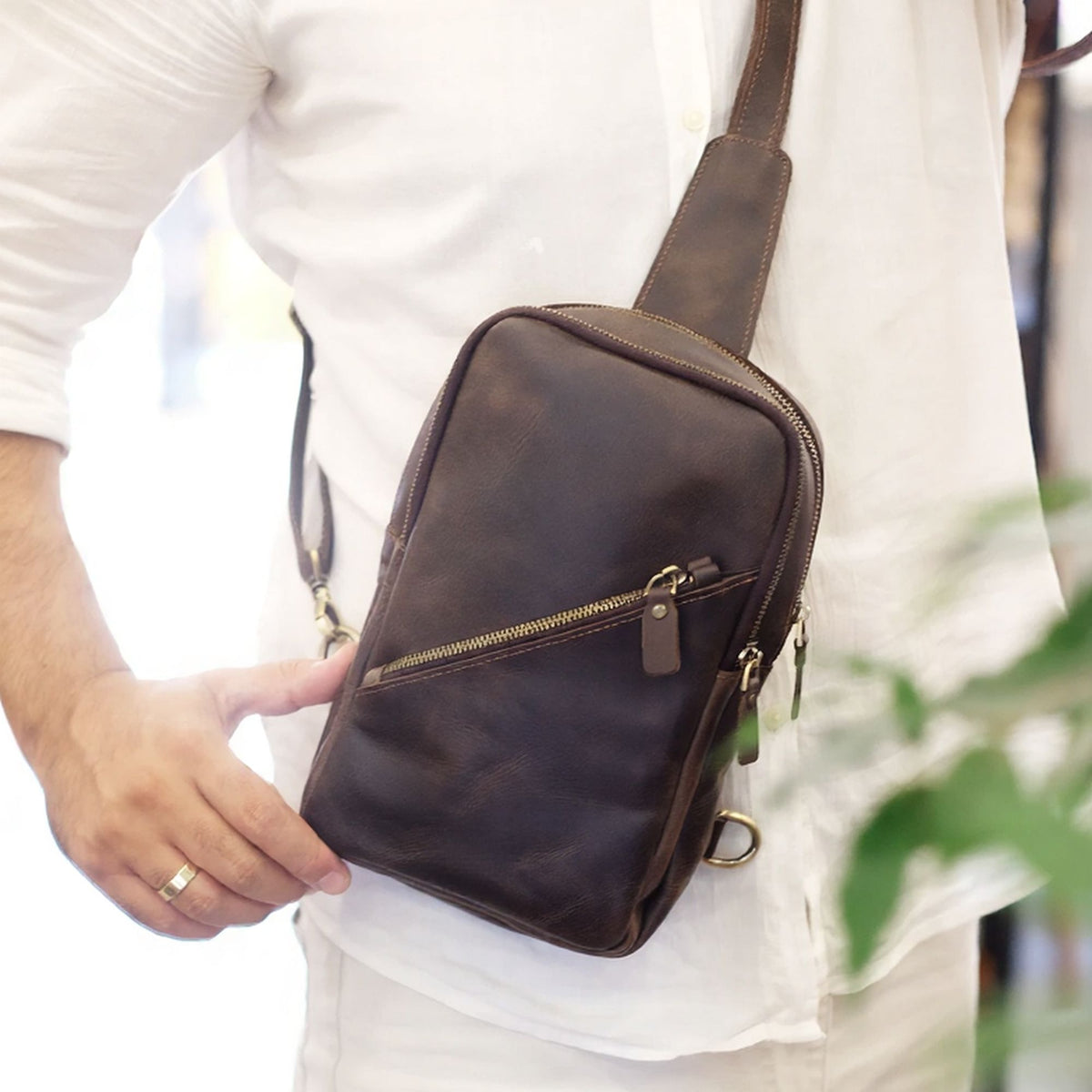 Strive handcrafted dark brown leather sling bag diagonal zip chest crossbody on model - Yubello