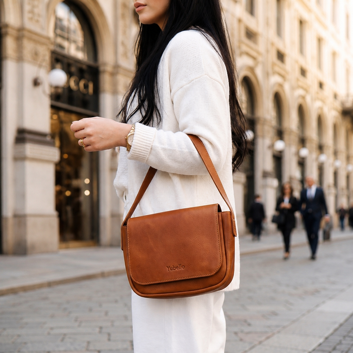 Monteria handcrafted leather flap shoulder purse worn crossbody by woman on city street with debossed logo - Yubello