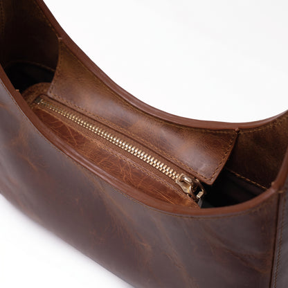 Norelle handcrafted brown Crazy Horse leather crescent shoulder bag front view - Yubello